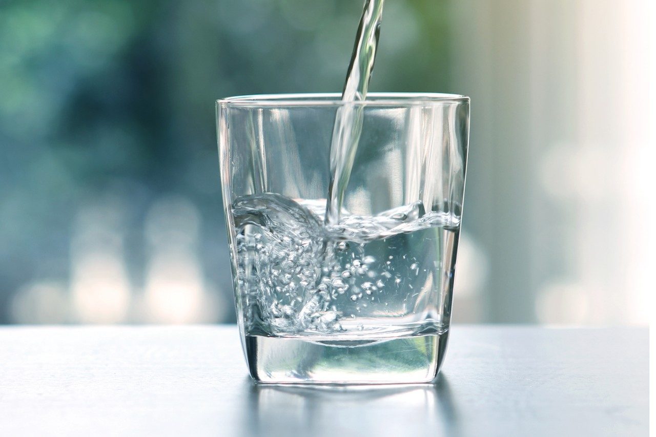 Drinking water pouring into glass on table