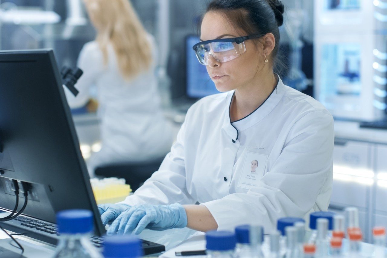 Researcher typing on keyboard in lab