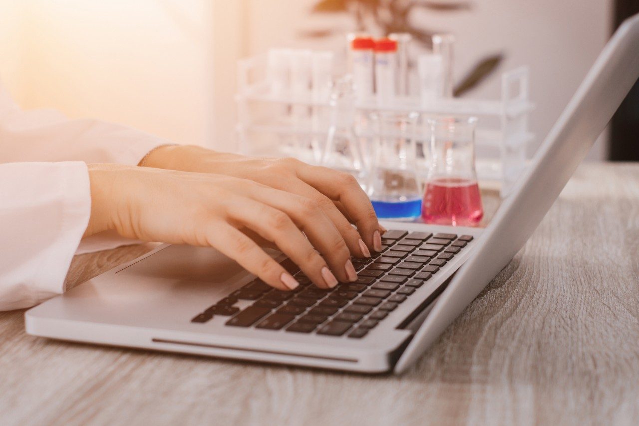 Scientist working on chemistry lab computer