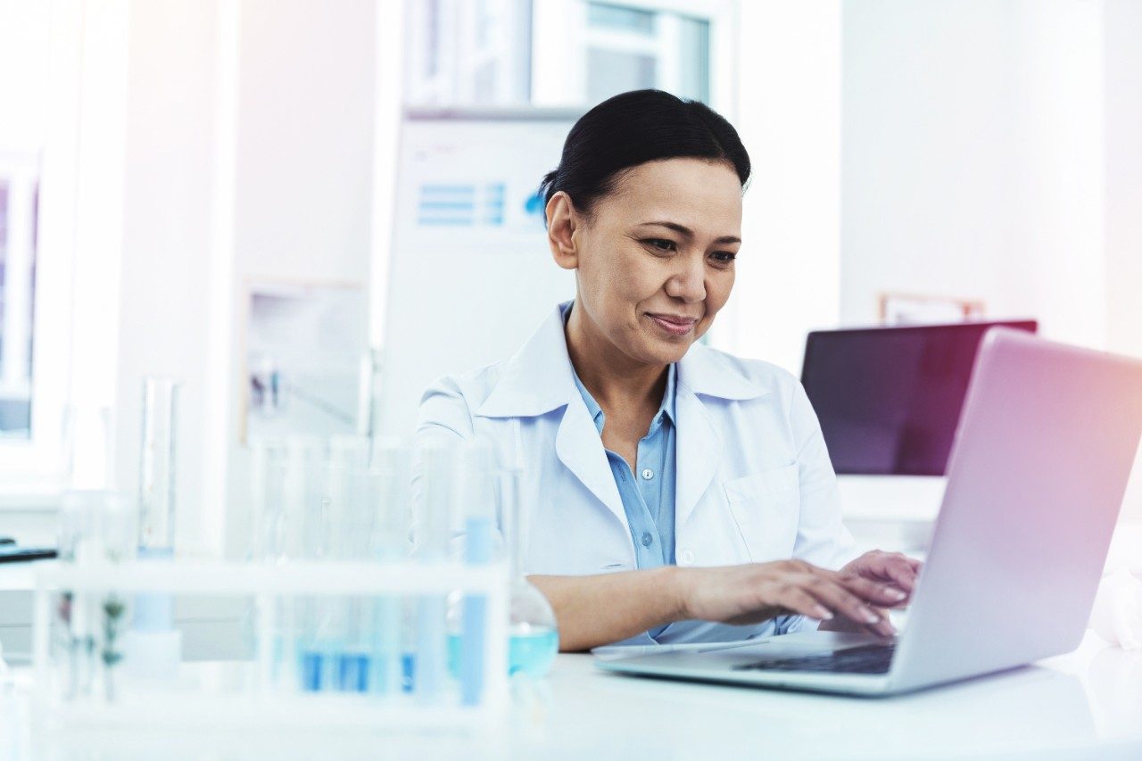 Scientist researching on latop in lab