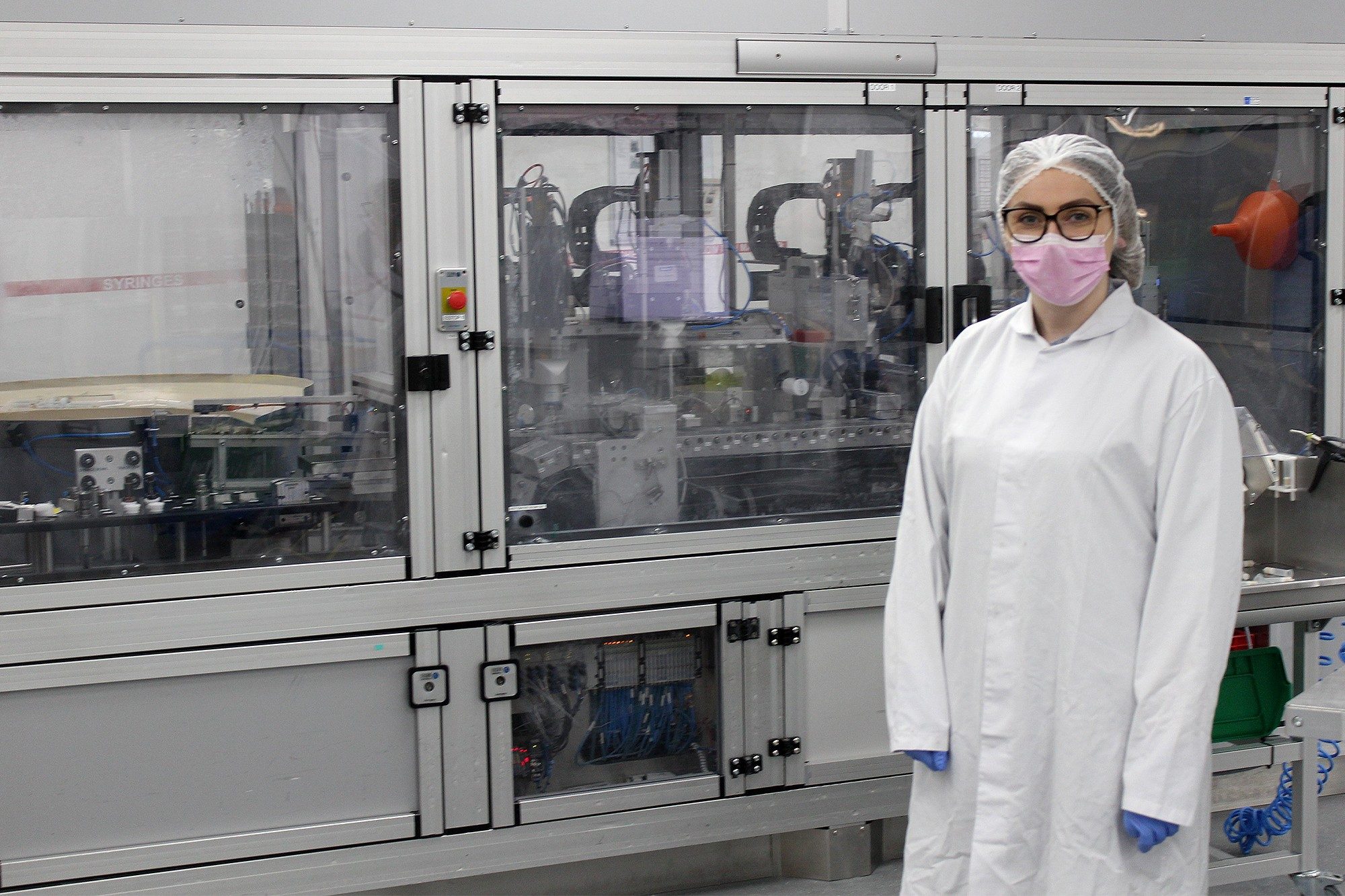 Emma Whelan en el laboratorio de Waters con bata de laboratorio, mascarilla, redecilla y gafas