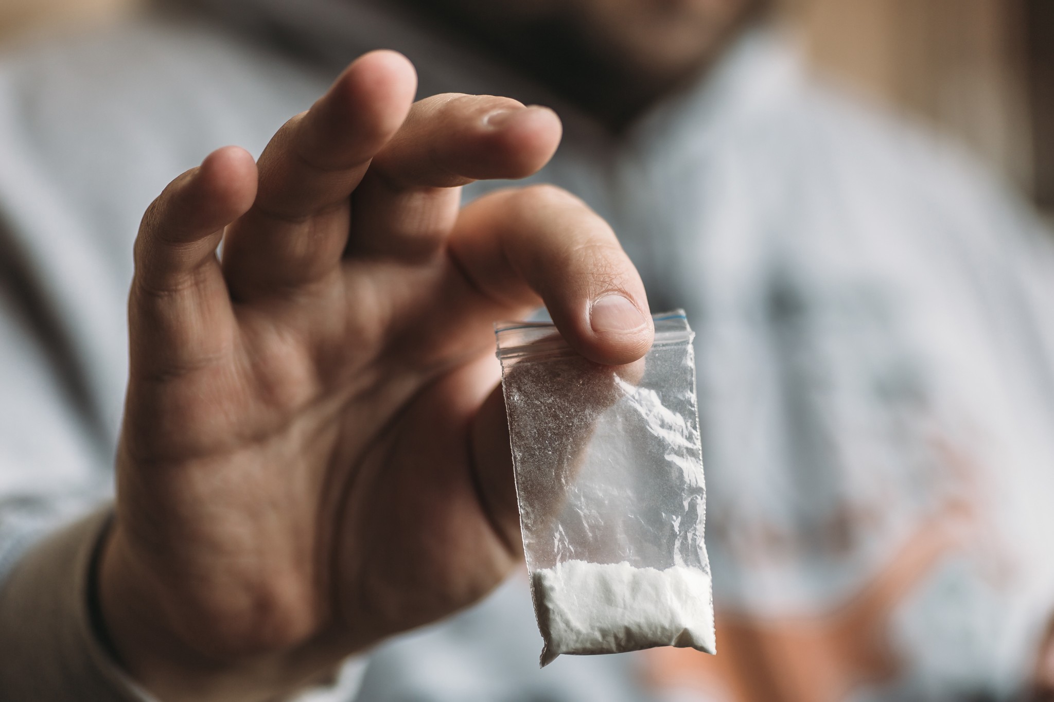 Main d’homme tenant de la poudre de cocaïne ou d’autres drogues